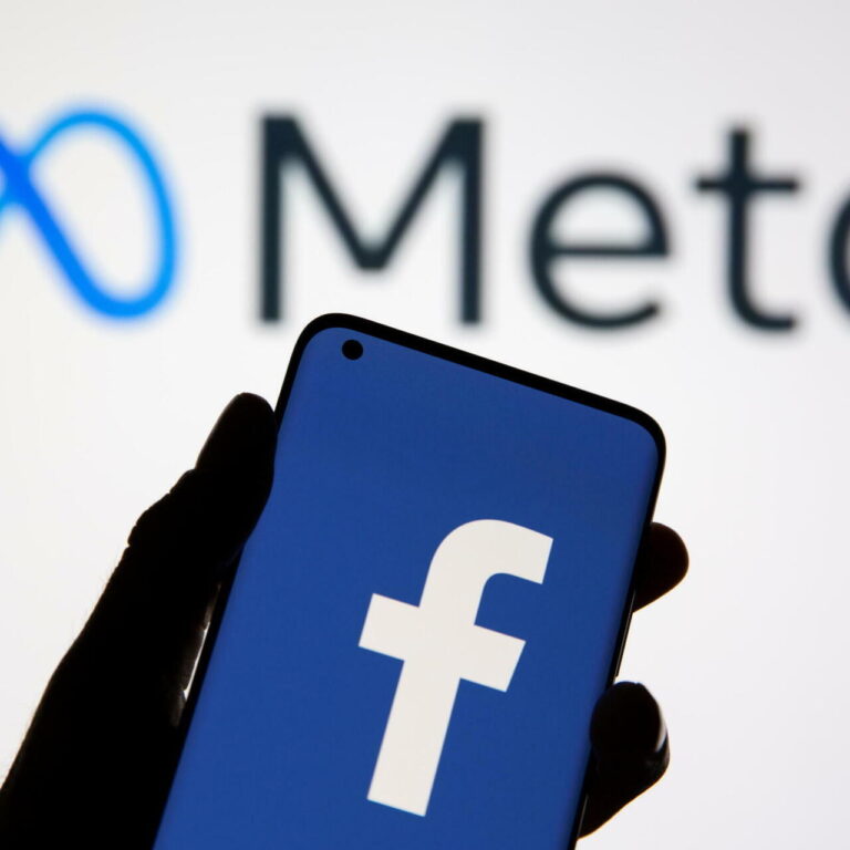 A smartphone with Facebook's logo is seen in front of displayed Facebook's new rebrand logo Meta in this illustration